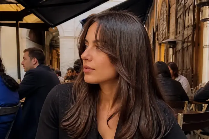 Donna con capelli lunghi e frangia a tendina in un ambiente esterno